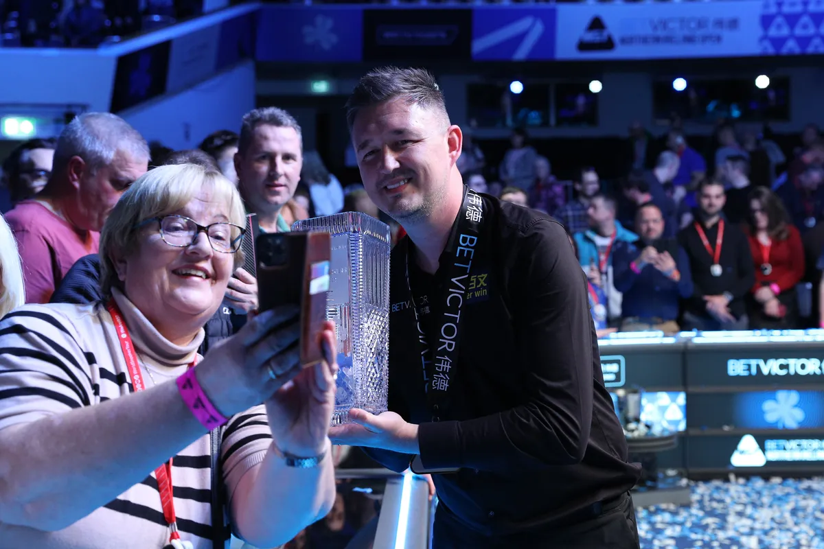 Wilson shares the Alex Higgins Trophy with a supporter