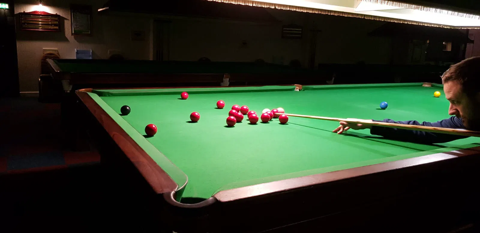Cơ thủ ngắm cơ chuẩn bị đánh bi quanh cụm bi trong trận snooker