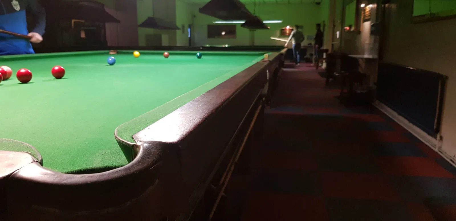 Cơ thủ chuẩn bị thực hiện cú đánh trong một trận snooker tại câu lạc bộ